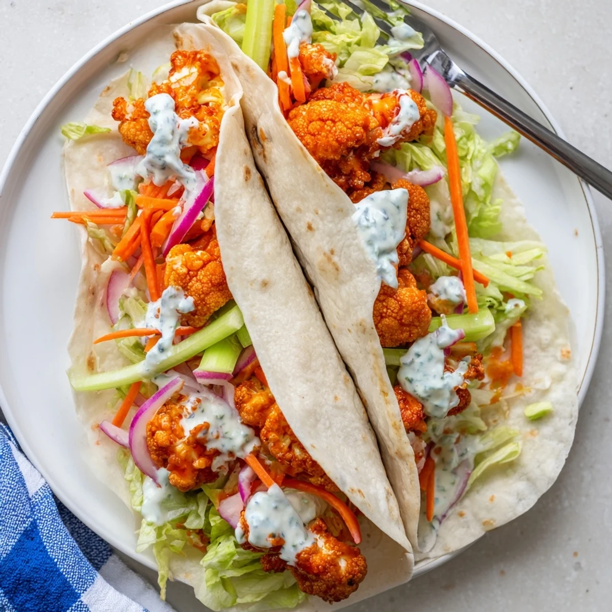 Hearty buffalo cauliflower wraps loaded with crunchy vegetables and creamy blue cheese dressing.