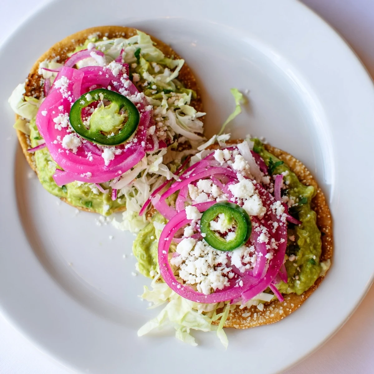 Tangy 5-Minute Pickled Red Onions layered on tacos, complete with crispy avocado crema and fresh cilantro.