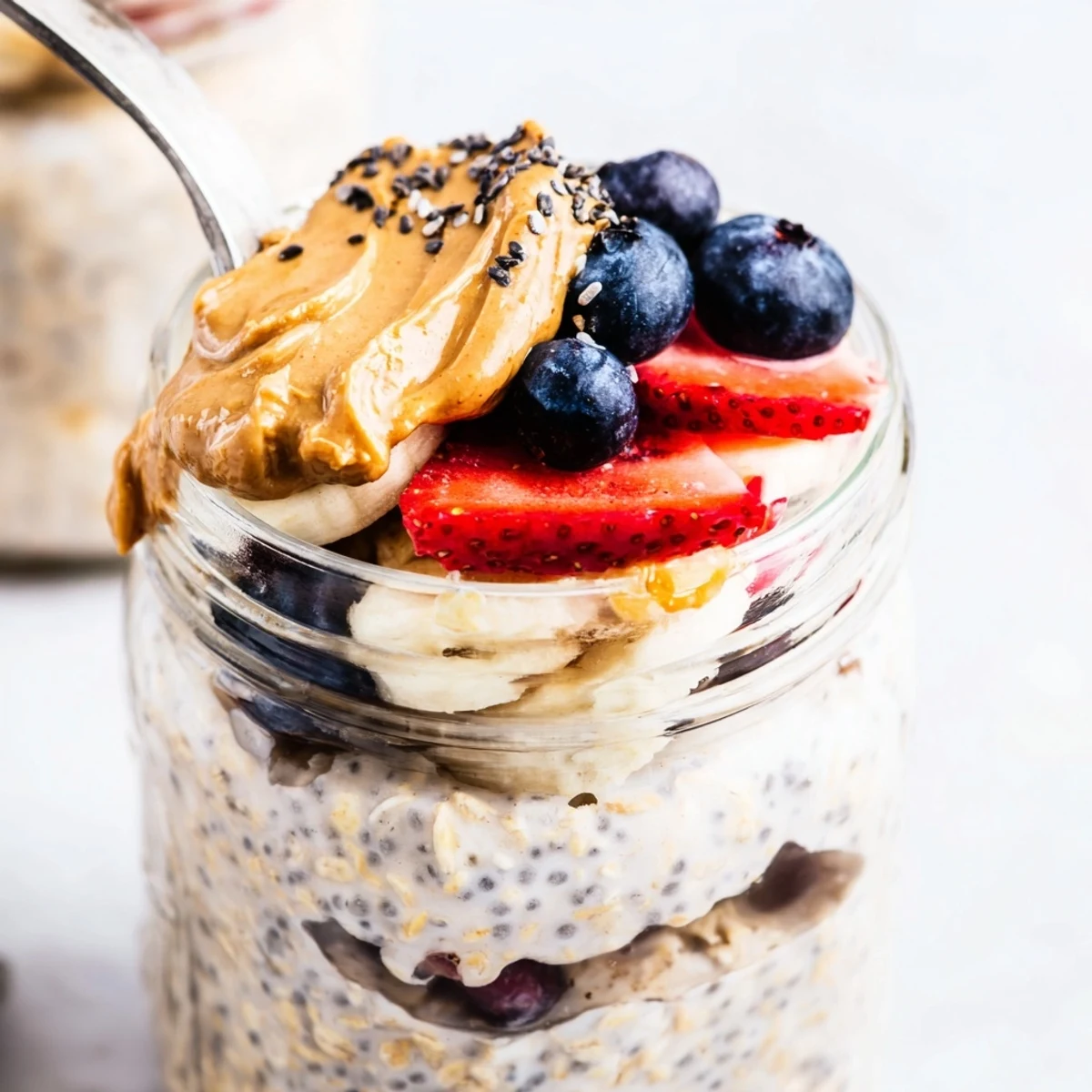 Creamy overnight oats jars layered with fruit and peanut butter, a delightful make-ahead breakfast.