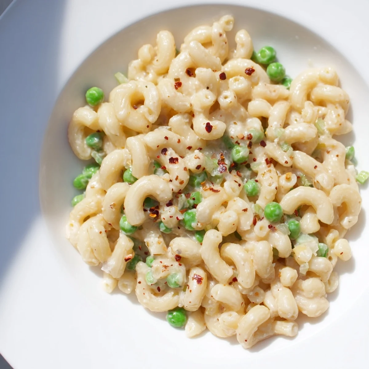 Steaming bowl of creamy Macaroni & Peas, a simple comfort food classic, ready to enjoy.
