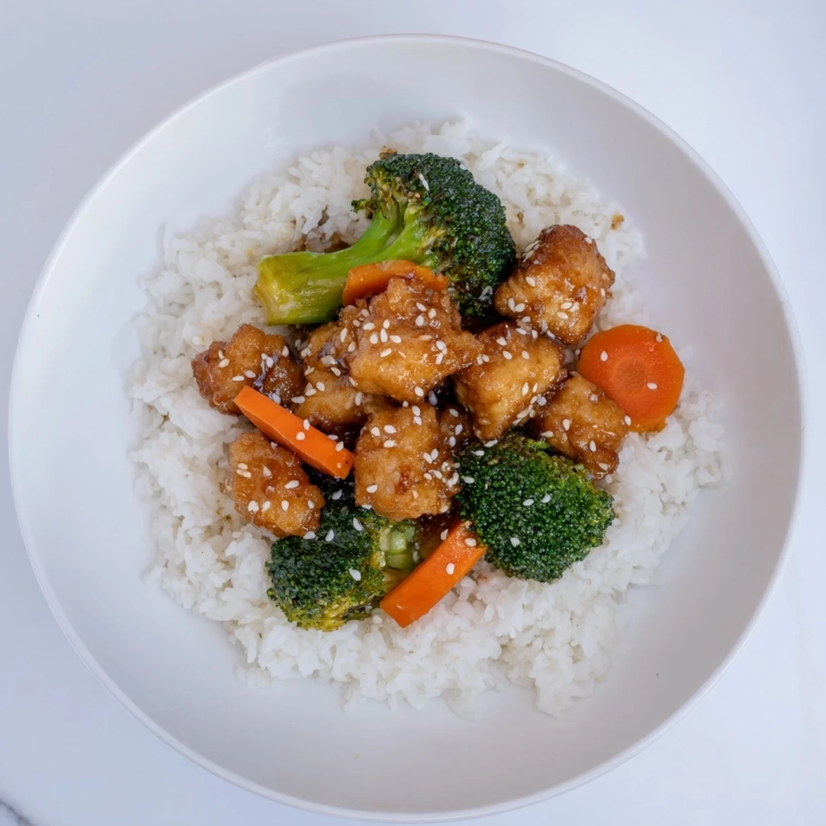 Golden-brown sesame tofu & broccoli, a delicious vegetarian meal served over fluffy rice.