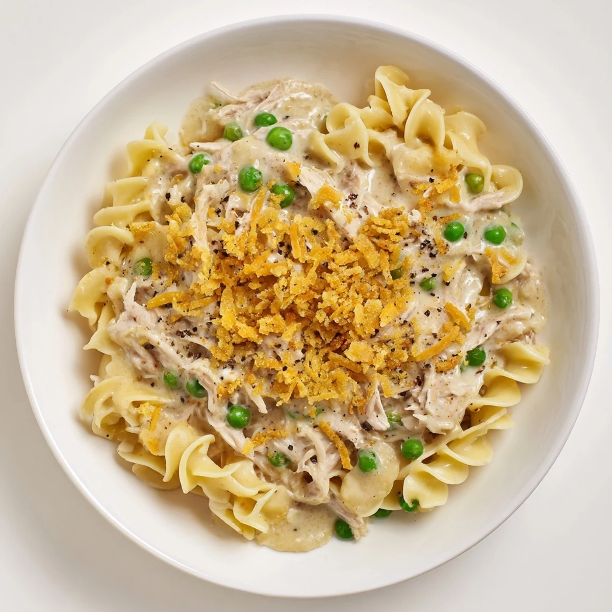 A casserole dish overflows with Creamy Tuna Noodle Casserole, showcasing a crispy Ritz cracker crust.