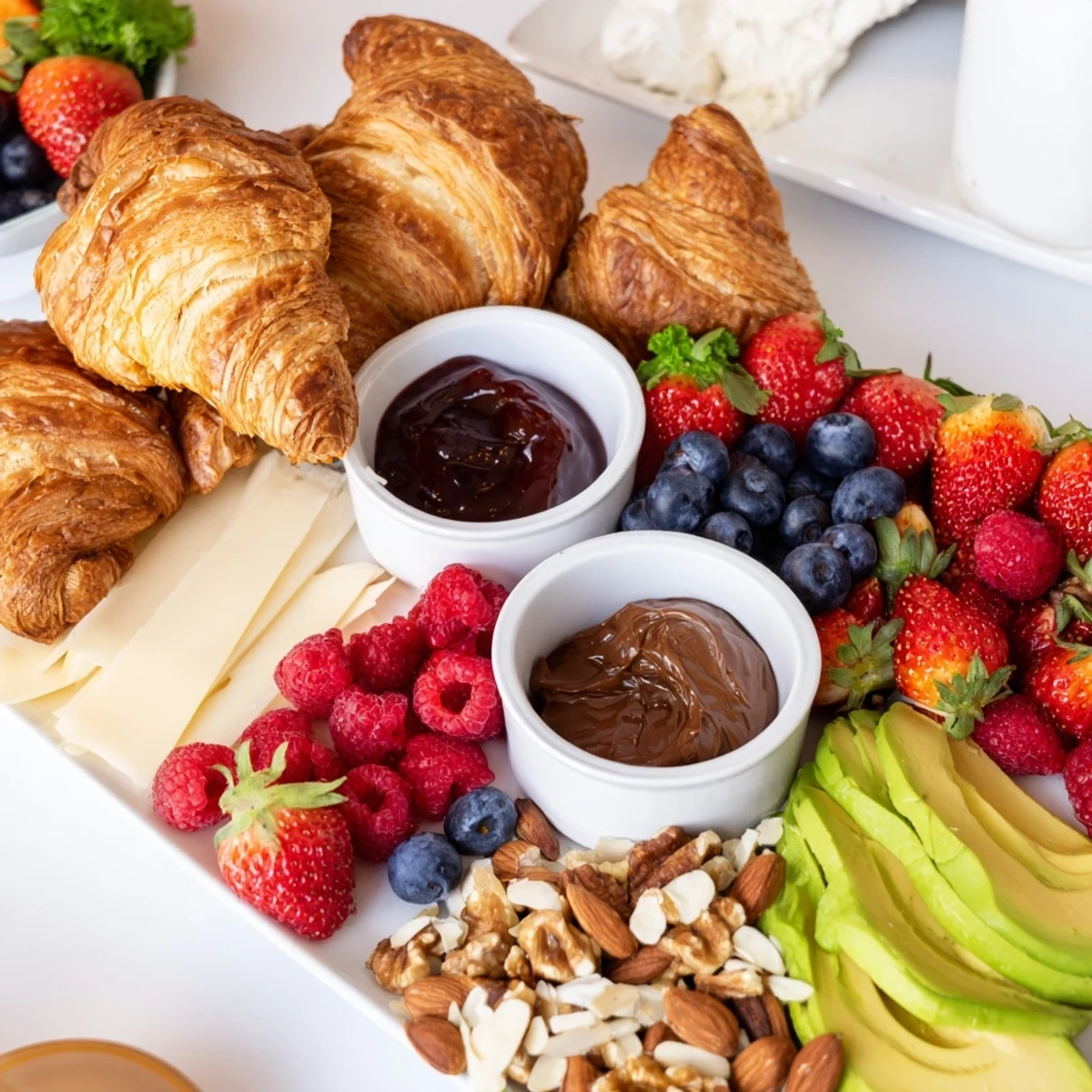 Warm, flaky Cozy Fireplace Croissant Board overflowing with berries, cheeses, and inviting spreads.