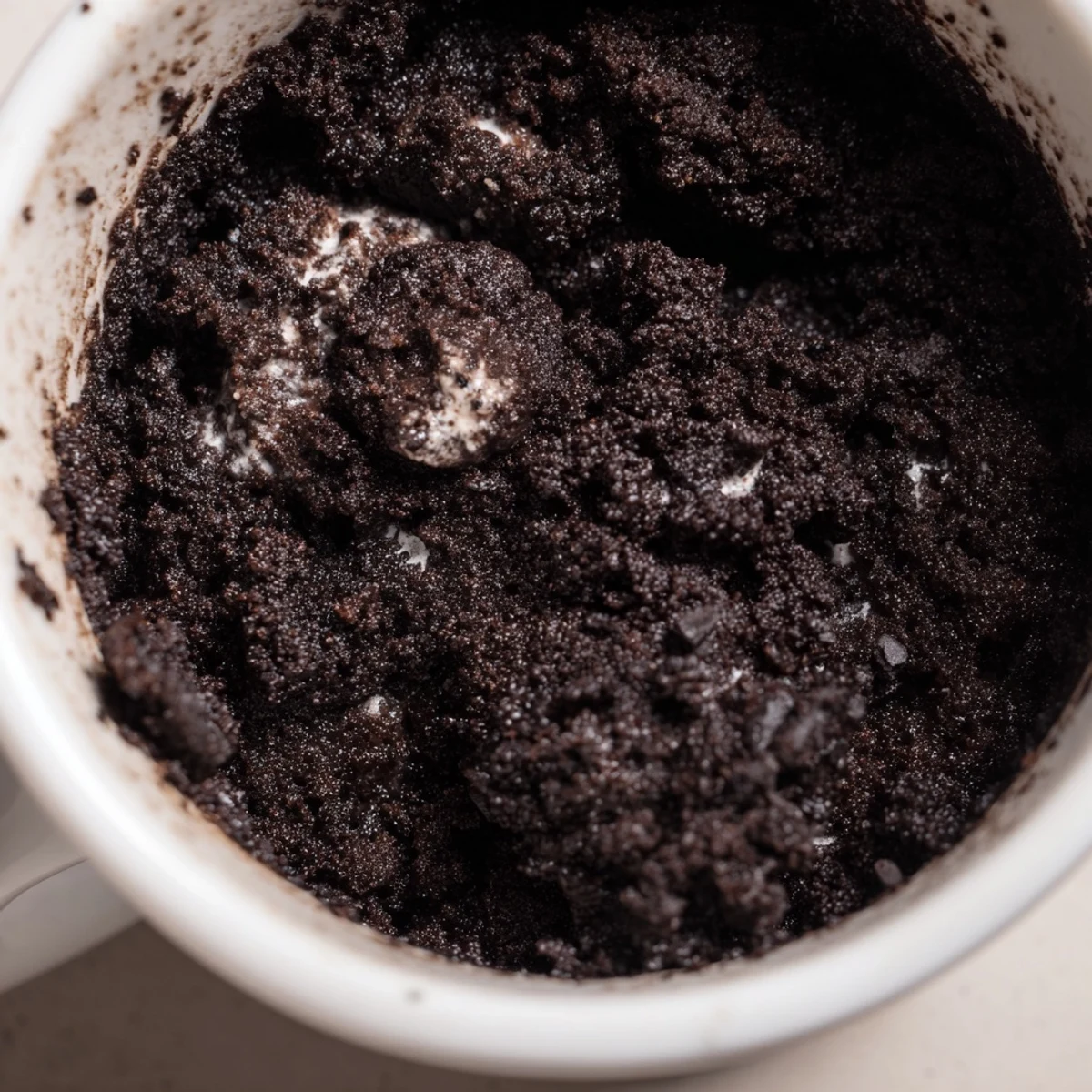 A single serving Oreo Mug Cake, rich chocolate with visible Oreo cookie pieces, ready to eat.
