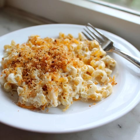 A steaming bowl of Easy Tinis Mac & Cheese with a bubbly cheese topping, ready to eat.