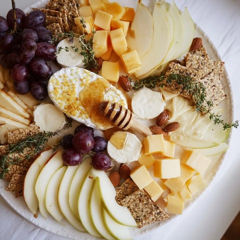 Golden honeycomb centers a vibrant Busy Bee Honeycomb Snack Plate with cheese, fruit, and snacks.