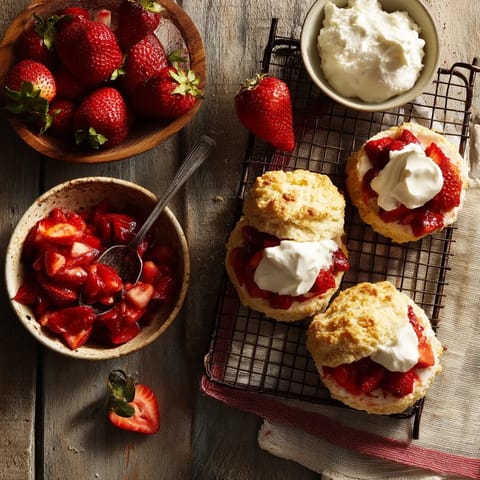 A plate of strawberries and a bowl of whipped cream.
