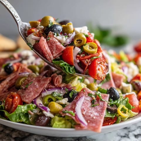 A stacked muffuletta salad on a plate.