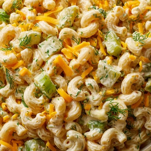 A dill pickle pasta salad with cheese and vegetables.