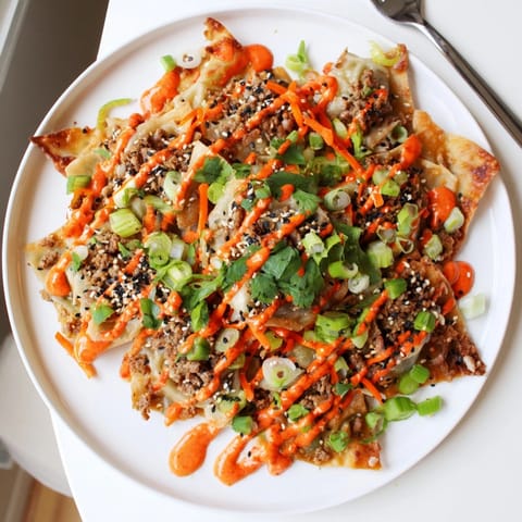 Crispy wonton chips covered in flavorful gyoza filling creating Japanese Gyoza Nachos.