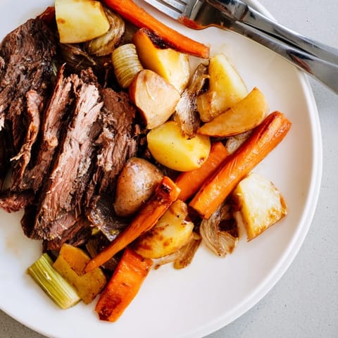 Hearty Sunday pot roast garnished with colorful roasted vegetables, perfect for family dinners.  