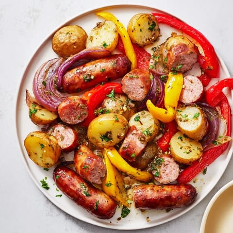 Golden potatoes and sizzling sausage are mixed with bell peppers and onions in this Sheet-Pan Sausage dinner.