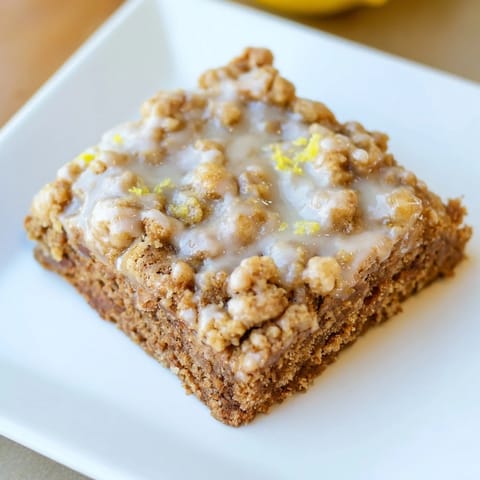 Buttery, spiced gingerbread crumble bars with bright lemon glaze, ideal for sharing and enjoying.