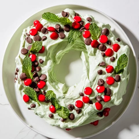 Creamy Mint Chocolate Chip Dip Wreath, adorned with festive red candies and mint, ready to serve.