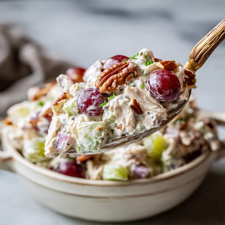 A spoonful of chicken salad with grapes.