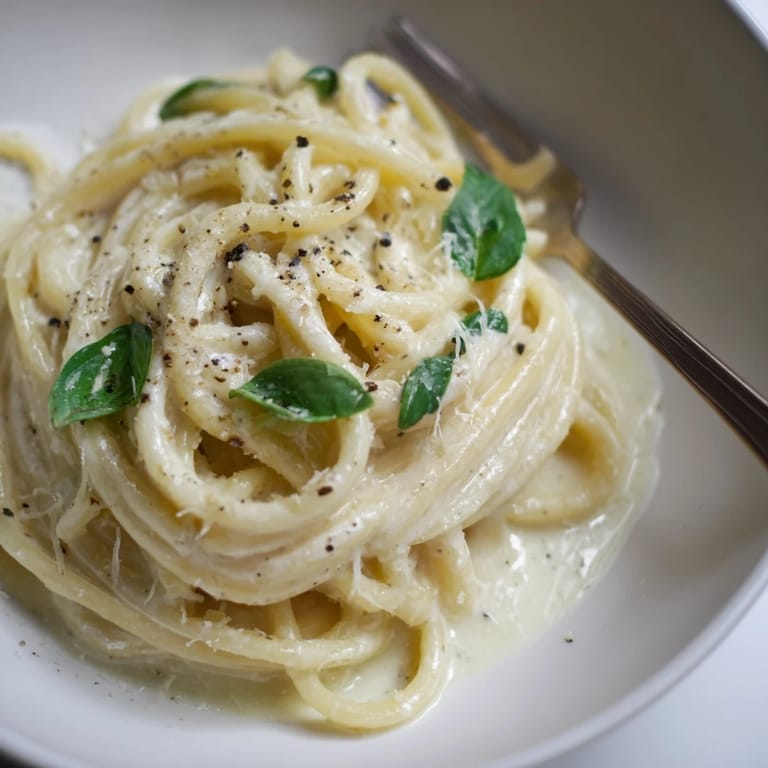 Creamy Lemon Basil Ricotta Pasta tossed with spaghetti, garnished with Parmesan and pepper.  