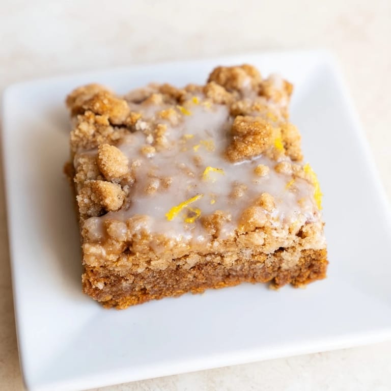 Freshly baked Lemon-Glazed Gingerbread Crumble Bars, a festive treat with warm gingerbread aromas.