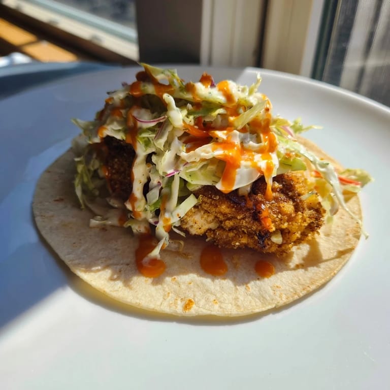 Juicy Buffalo chicken smash burger tacos with crispy edges and a vibrant, creamy slaw topping.