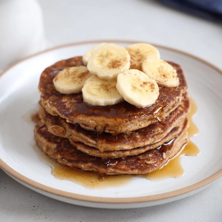 Close-up of freshly cooked banana oat pancakes, showcasing a light, airy texture and delicious flavor.