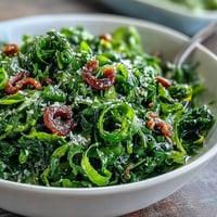 A vibrant arugula salad drizzled with lemon vinaigrette and topped with delicate Parmesan shavings for a zesty bite.