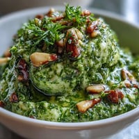 Fresh dandelion pesto with garlic and pine nuts, vibrant green and aromatic, perfect for pasta or sandwiches.