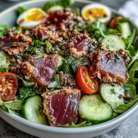 High-protein tuna salad bowl with hard-boiled eggs, fresh vegetables, and creamy yogurt dressing.  
