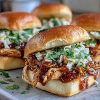 Apple BBQ Chicken Mini Sandwiches with fresh apple slaw on toasted slider buns.